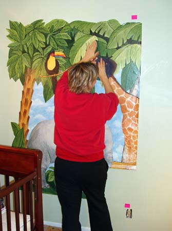The mural's about half way up as mom works on hanging the third panel.