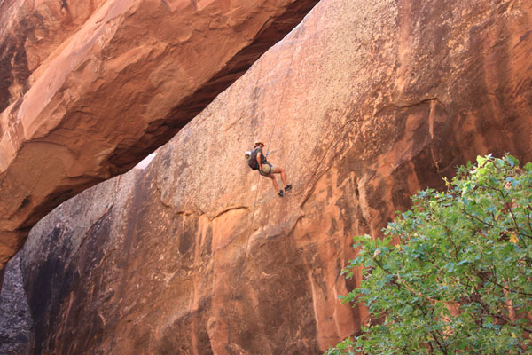 Rappelling near an arch in Moab